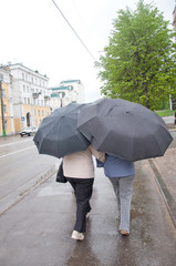 Two women go under umbrellas in heavy rain