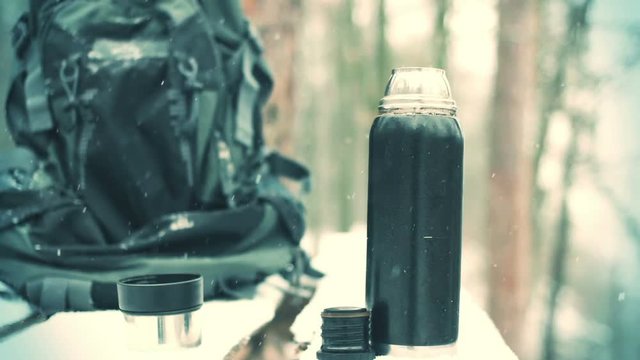 backpack and a thermos and falling snow, close-up