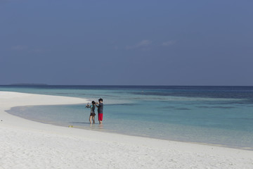 A young couple on vacation on a tropical island. White coral san