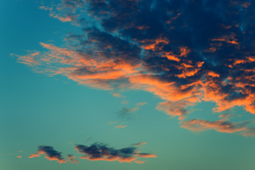 Fototapeta na wymiar Fluffy orange clouds in winter sunset