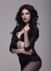 Fototapeta premium Sensual slim brunette lady posing in black sexy lingerie. Long curly hair.