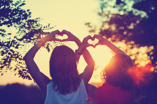 Girl-friends making a heart-shape for the sunset. Shallow depth of field on the hands.
- Powered by Adobe