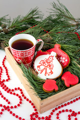 Ginger biscuits and a Cup of tea on the table with branches of s