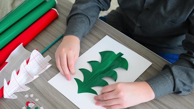 Teen Boy making Christmas card from color paper