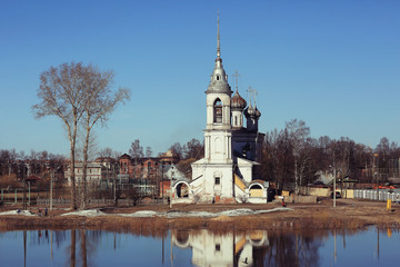 Fototapeta na wymiar Church on the river autumn landscape in Russia