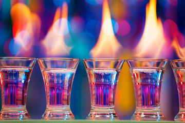 Hot shot glasses standing in a row on bar counter