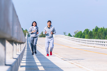 smart couple running on bridge. Healthy lifestyle love couple of cardio together in outdoors.
