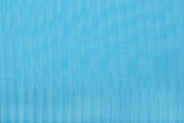 Blue pleated transparent caprone cloth as background texture