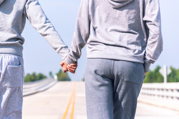 smart couple walking and hold hand on bridge . Healthy lifestyle love couple of cardio together in outdoors.

