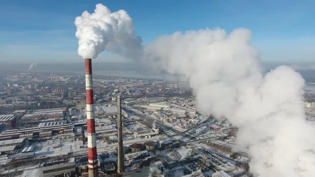 Fuming pipe on the background of a winter city, aerial view