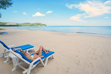 Tropical vacation. Young beautiful woman relaxing on the beach.