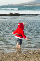 santa boy at sand beach water
