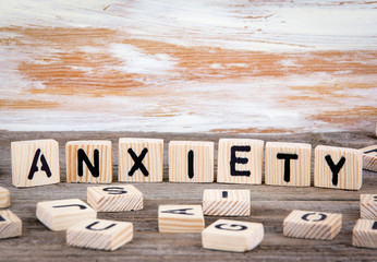 Anxiety from wooden letters on wooden background.