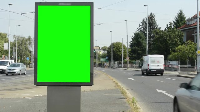 view of the billboard stands on the side of two roads in suburb - green screen