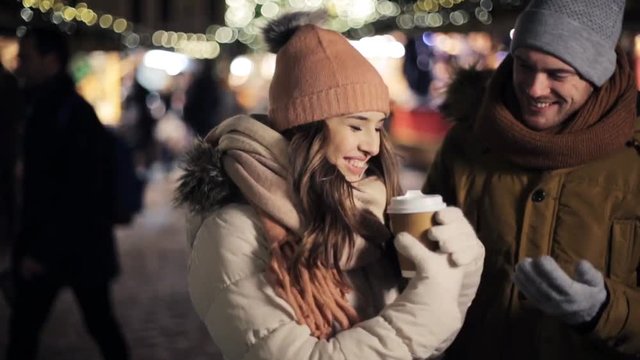 happy couple with coffee at christmas market