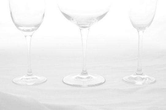 Three stemmed glasses, empty on a white background