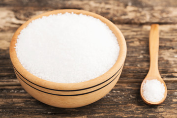 Wooden bowl and salt on wooden background