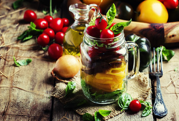 Rainbow salad from colorful tomatoes, onion, pepper and basil wi