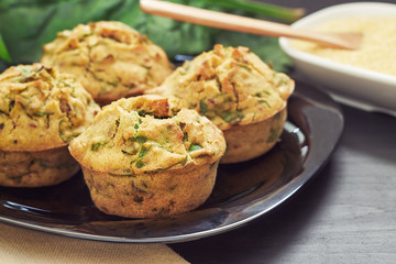 Vegan muffins with spinach and corn flour served on black plate