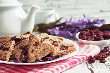 Whole wheat cookies with dried cranberries on white rustic wooden background