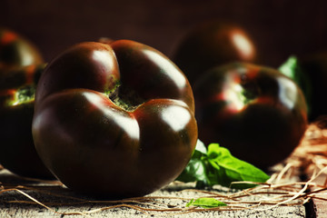 Large black tomatoes, rustic style, selective focus
