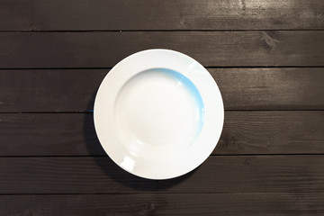 Empty white plate on wooden table