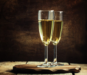 Glasses of champagne on the old wooden table, rustic style, sele