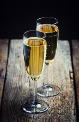 Glasses of champagne on the old wooden table, rustic style, sele