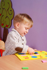 Little boy playing and learning in preschool