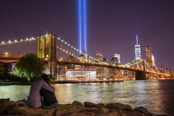 Fototapeta na wymiar Lovers embrace while watching the tribute in lights memorial