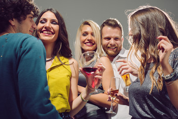 Happy friends having fun. Home party. Lot of confetti around them.