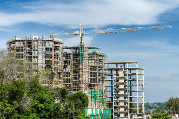 Large crane and building construction site against blue sky and