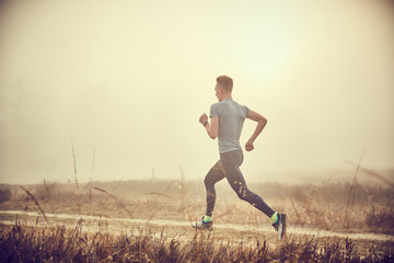 Ragazzo atletico si allena all'aperto su terra di sera © CreativePhotography