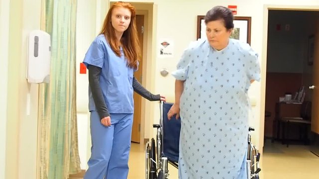 Nurse allowing patient to stand up from wheelchair and sit back down

