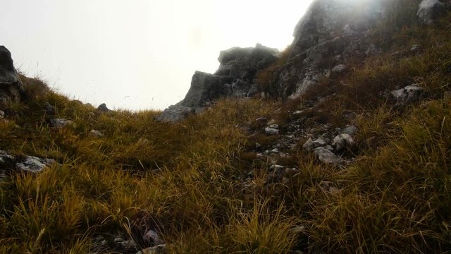 motion along the rocky terrain in autumn misty mountains