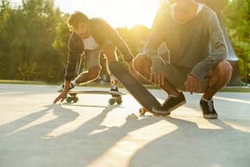 Skater friends performing with longboards in city urban park