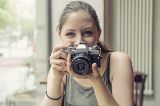 Portrait of smiling young woman holding a camera