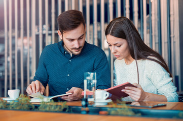 Fototapeta premium Students in cafeteria on a coffee break reading a book