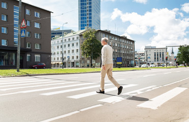 Fototapeta na wymiar senior man walking along city crosswalk