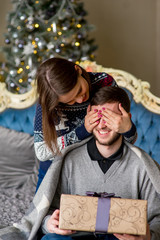 Fototapeta premium Kobieta robi mężczyźnie niespodziankę na Boże Narodzenie