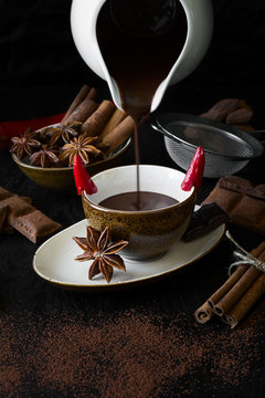 Cup of hot chocolate with chili pepper on dark wooden background