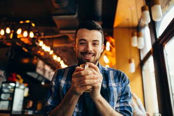 Handsome natural man looking at the camera and drinking tea