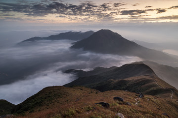 Clouds rolling over a mountain on Lantau Island, viewed from the Lantau Peak (the 2nd highest peak in Hong Kong, China) at dawn.