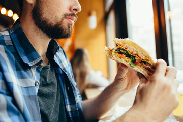 Man in a restaurant eating a hamburger