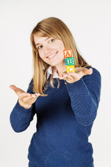 woman holds a cube with letters