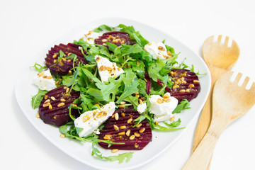 Salad of baked beet, homemade goat cheese, arugula and pine nuts, selective focus