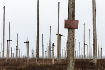 Many concrete pillars with the tablet for an inscription in a field near a disused power station.