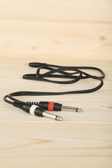 Audio cable on wooden table, flat lay close up. Selective focus