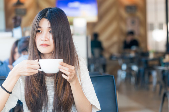 Young charming asian student woman hold cup of coffee drink