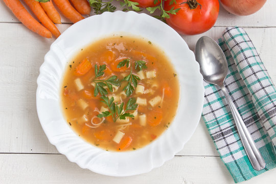 Minestrone soup in plate on white wooden table